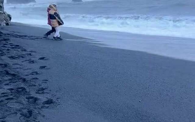 Toeristen op een strand in IJsland maken kennis met de ruige oceaan