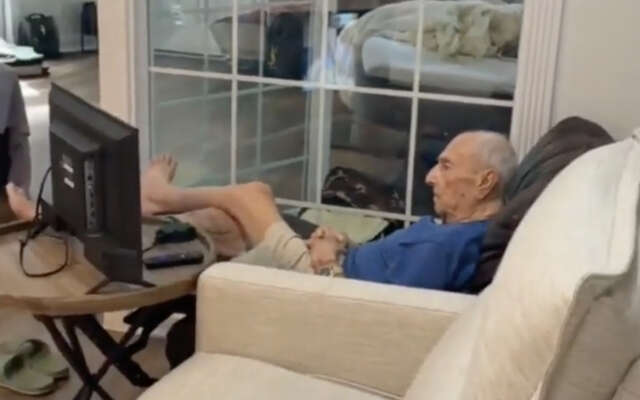 Opa geniet van een interessante documentaire op tv